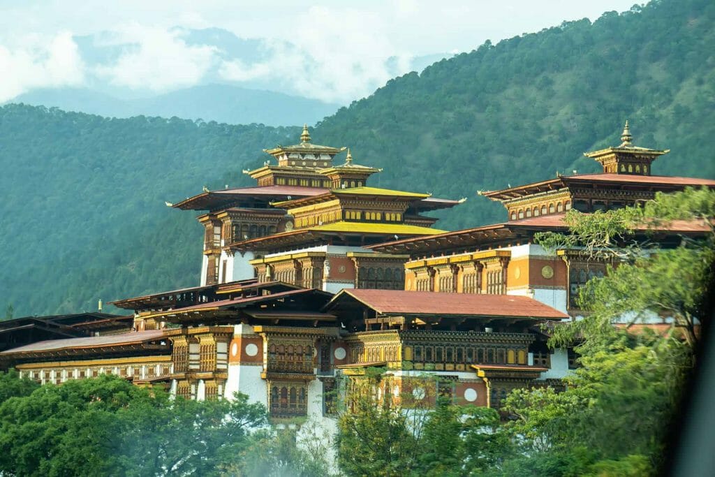 A view of a bhutan palace from the window of a car.