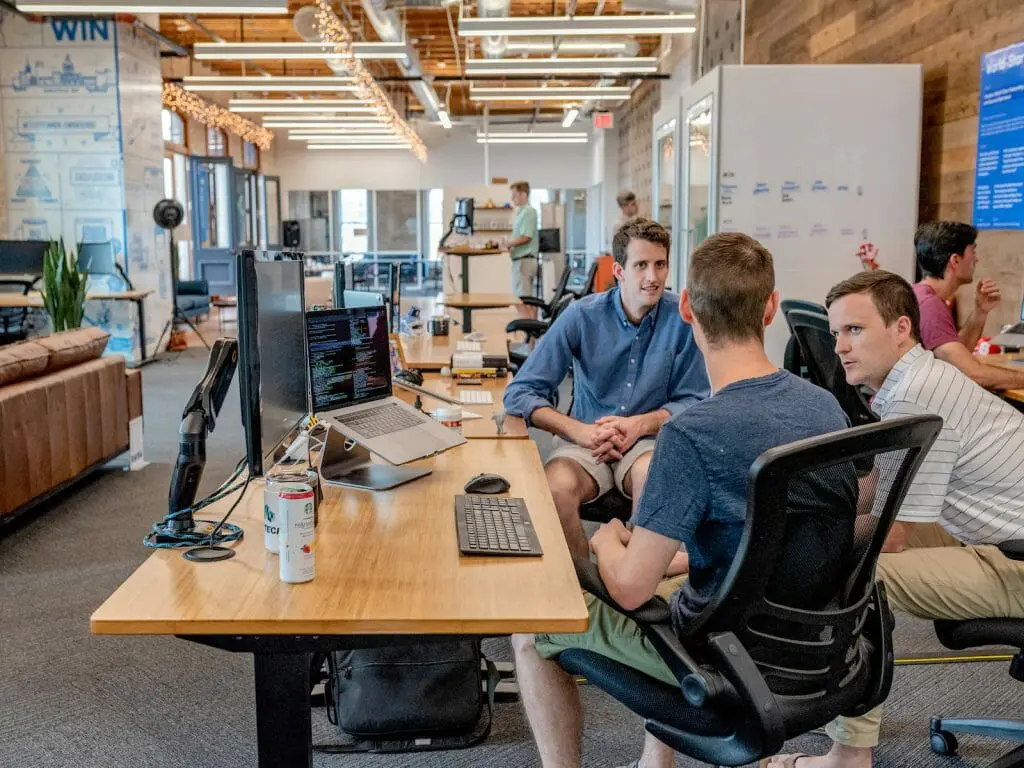 work with us, as here you can see three workers discussing new marketing strategies