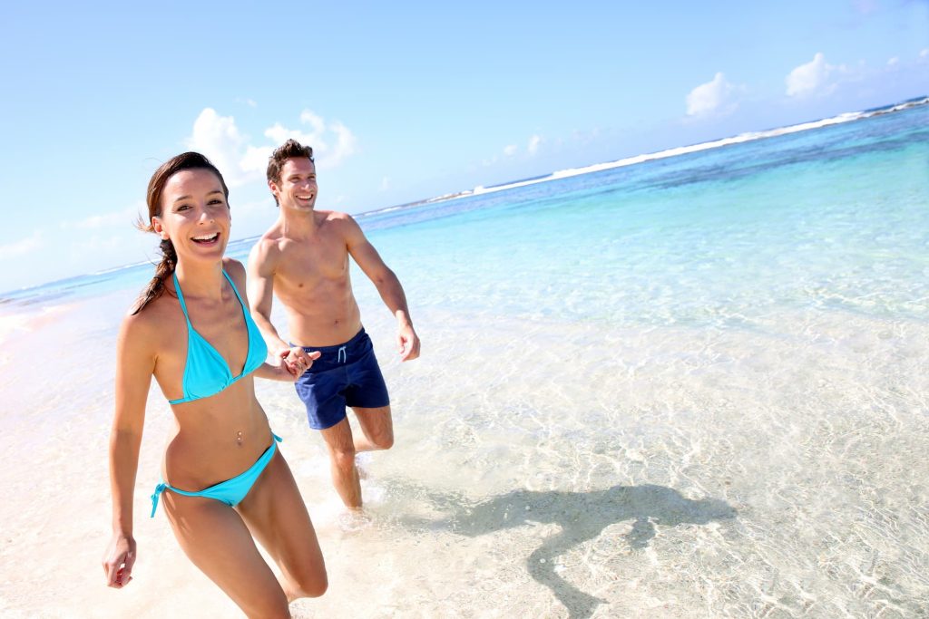 Couple running on a sandy beach on their Caribbean vacation — Photo