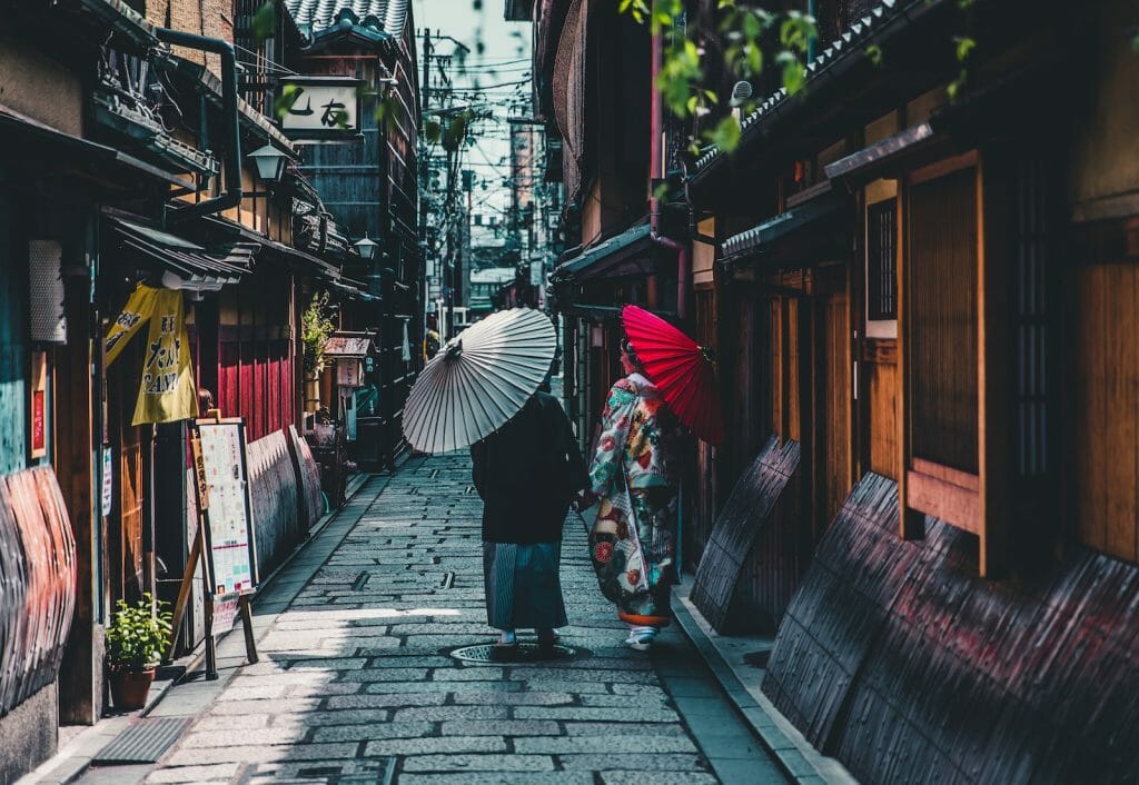 person walking on street while holding umbrella on  an exciting travel in Asia