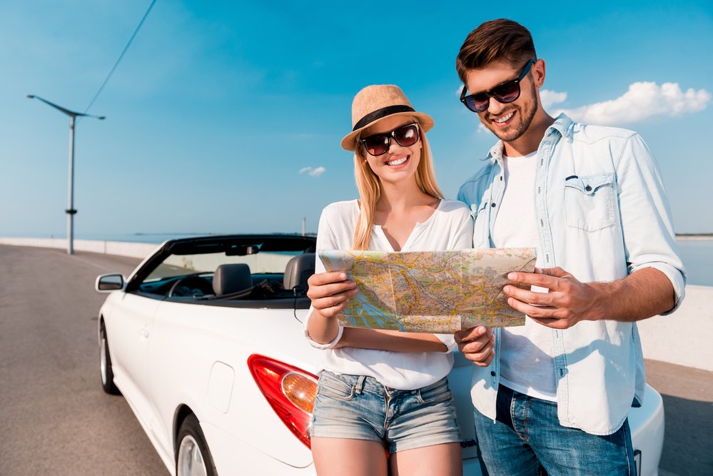 Couple examining map near convertible — Photo