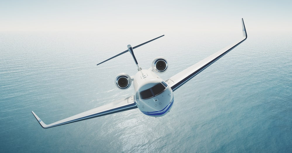 Image of white luxury generic design private jet flying over the empty sea. Blue sky at background. Luxury travel concept. Horizontal . 3d rendering — Photo