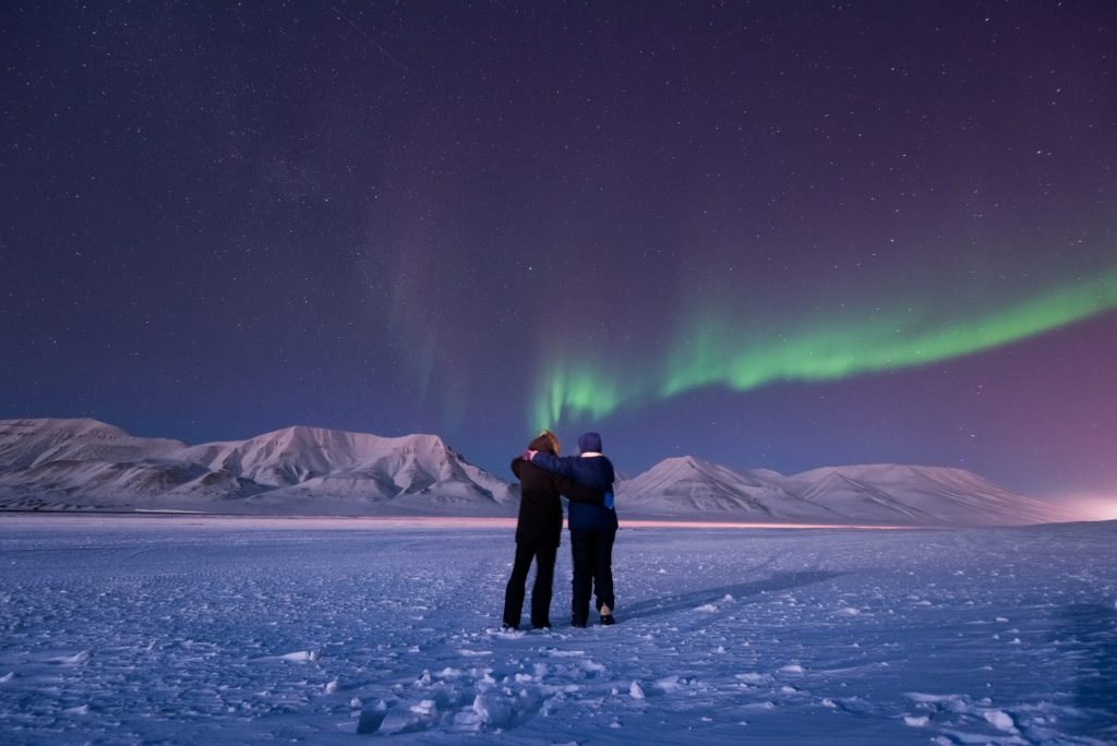 The polar arctic Northern lights aurora borealis sky star in Norway Svalbard in Longyearbyen city man people mountains — Photo