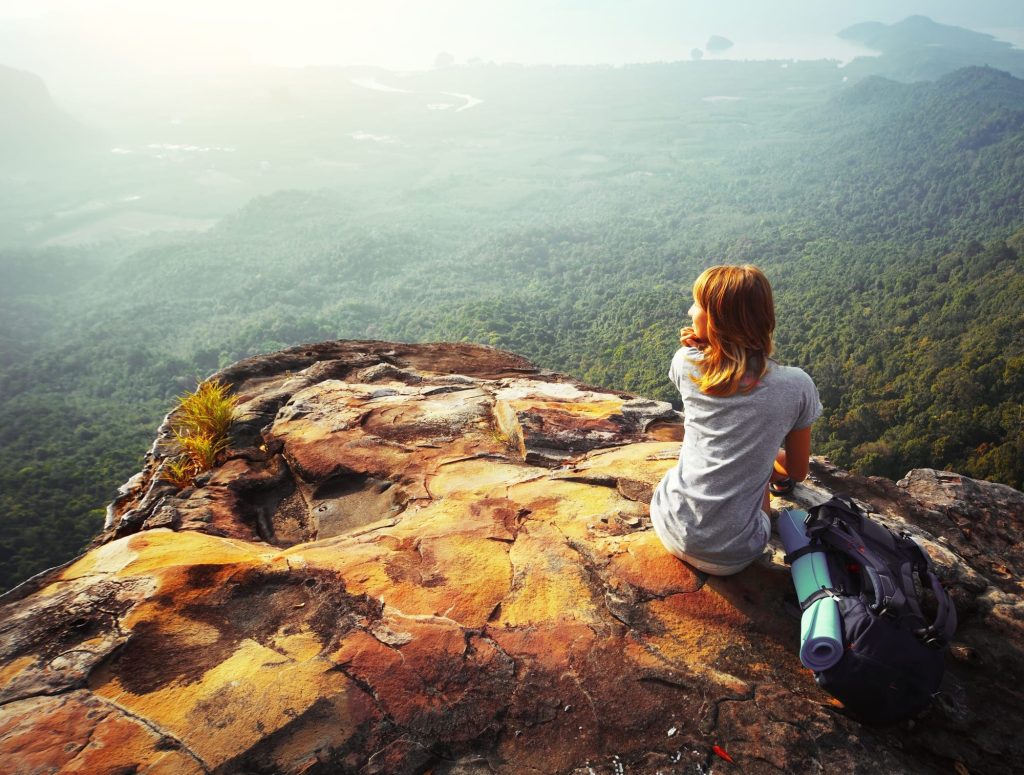 Young woman sitting on a rock during a luxury ecotourism trip