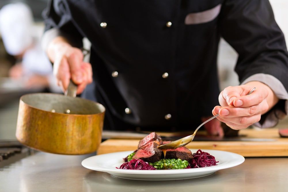 Chef in hotel or restaurant kitchen cooking — Photo