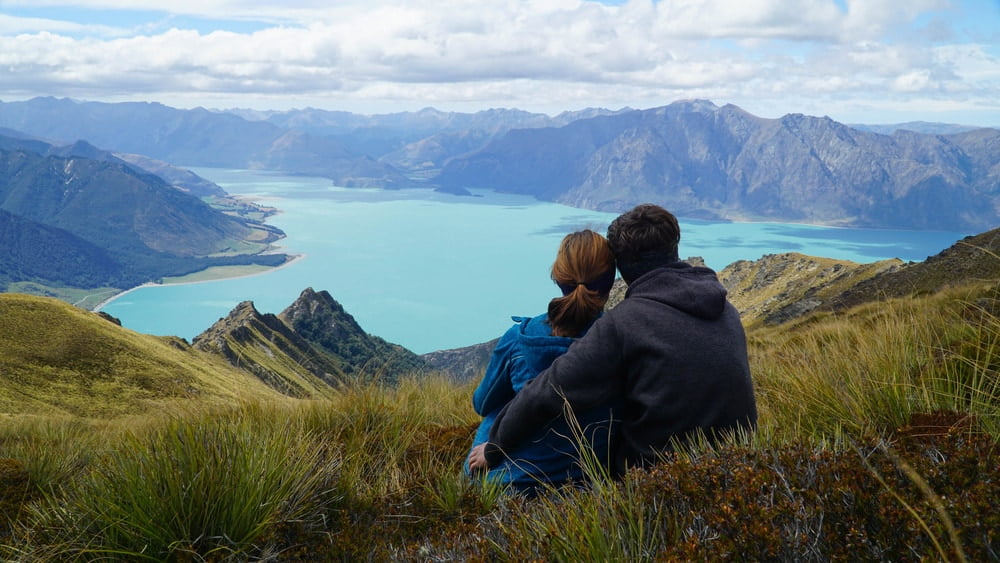 Couple enjoying a view of lake Hawea from Isthmus Peak, New Zealand — Photo