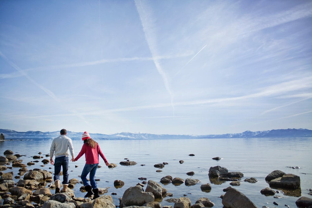 Couple walking on rocks near lake Tahoe