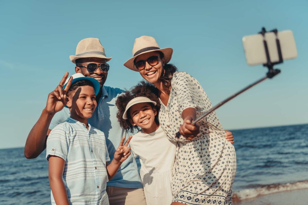 Family taking selfie on beach in Hawaii, one of the best Family Vacation Destinations 