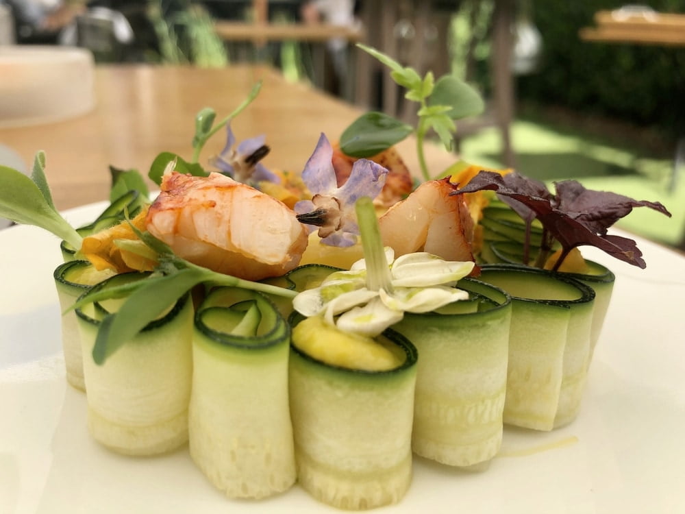 Fine dining, creative lobster dish served cucumber and flowers in michelin star restaurant