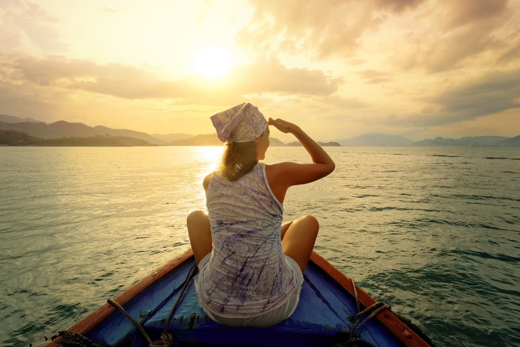 Woman traveling by boat at sunset among the islands — Photo