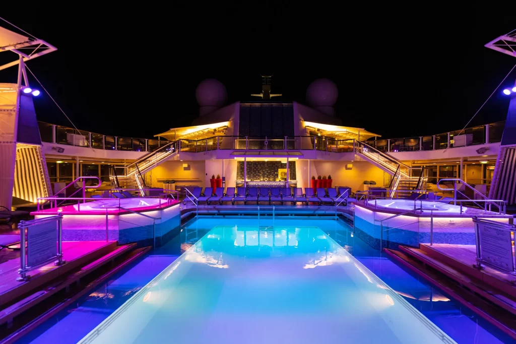 The luxurious pool is lit up at night on a Caribbean cruise.