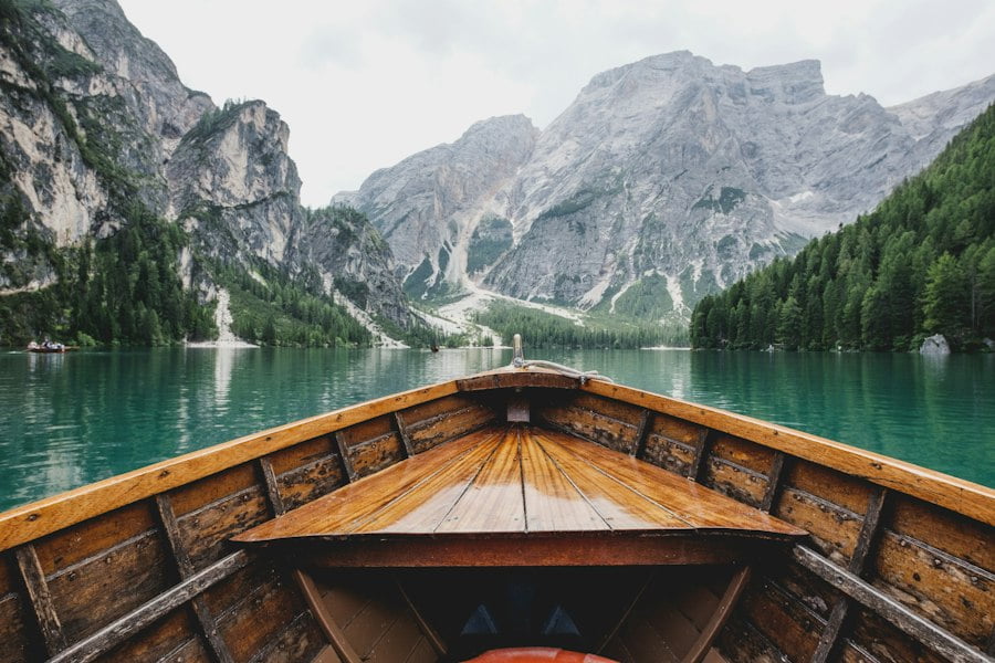 An adventure travel boat on a lake with mountains in the background.