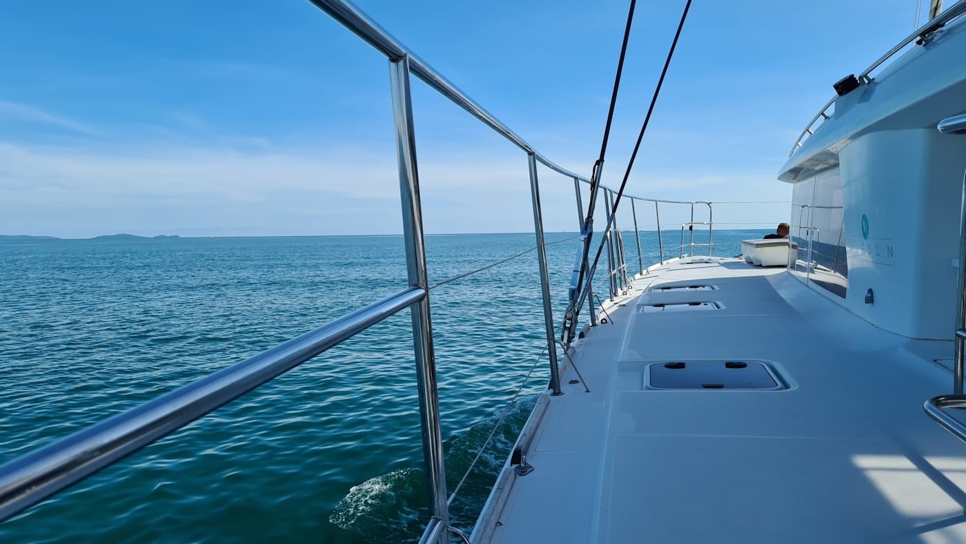 The serene deck of a catamaran with a breathtaking view of the ocean awaits you during your yacht charters in Central America.